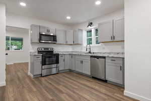 Kitchen with stainless steel appliances, dark hardwood / wood-style flooring, a healthy amount of sunlight, and decorative backsplash