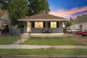 Bungalow-style home featuring a front yard and covered porch. Virtually added lawn.