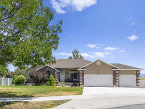 Single story home with a 3 car garage and a front lawn.