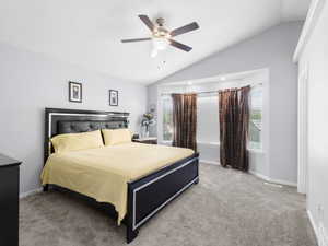 Master Bedroom with carpet and light green colored walls, with new ceiling fan and vaulted ceiling.