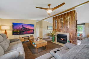 Carpeted living room featuring a textured ceiling, vaulted ceiling, and ceiling fan