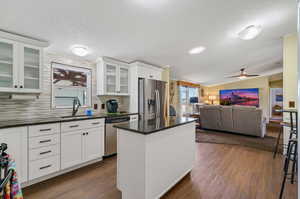 Kitchen featuring decorative backsplash, dark hardwood / wood-style floors, ceiling fan, appliances with stainless steel finishes, and sink