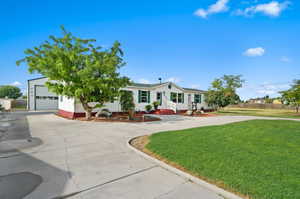 View of front facade featuring a garage and a front yard