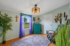 Bedroom with lofted ceiling, light hardwood / wood-style flooring, and a textured ceiling