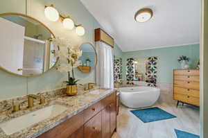 Primary suite bathroom featuring double vanity, a free standing tub