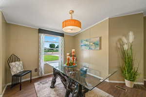 Dining room featuring dark hardwood / wood-style flooring, a textured ceiling, and vaulted ceiling