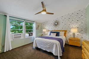 Primary bedroom with ceiling fan, a textured ceiling, and cooling unit