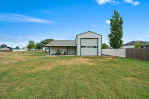 View of outdoor structure featuring a yard and a garage