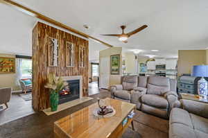 Living room featuring ceiling fan, a fireplace, light hardwood / wood-style flooring, and a textured ceiling