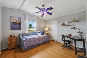 Bedroom with ceiling fan, wood-type flooring, a textured ceiling, and lofted ceiling