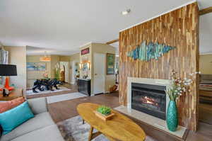 Living room featuring wood-type flooring, double sided fireplace and a textured ceiling