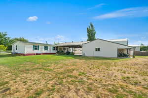 Rear view of house with a yard