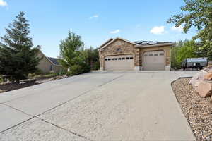 View of front of property featuring solar panels and a garage