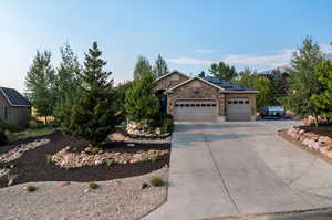 View of front of home with solar panels and a garage