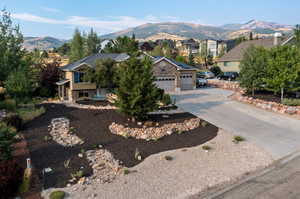 View of front of home with a mountain view and a garage