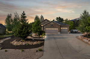 View of front facade featuring a garage and solar panels