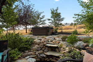 View of yard with a rural view and a hot tub