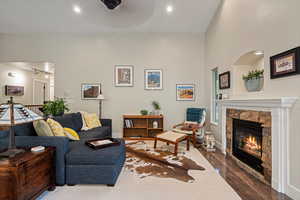 Living room with ceiling fan, a fireplace, and hardwood / wood-style flooring