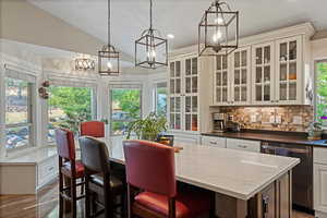 Kitchen with white cabinets, lofted ceiling, and plenty of natural light