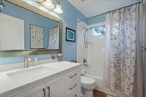 Full bathroom with shower / bath combo, toilet, and vanity