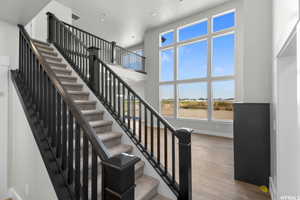 Stairway with hardwood / wood-style flooring and a high ceiling