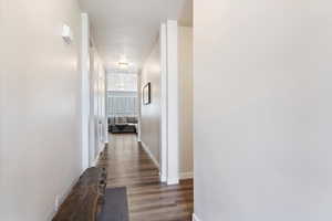 Hallway with hardwood / wood-style floors