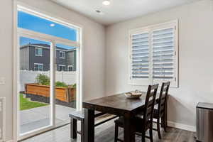 Dining space with hardwood / wood-style floors and a healthy amount of sunlight