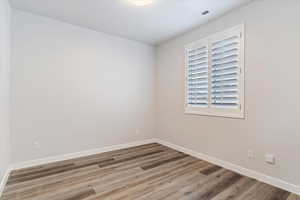 Guest Bedroom 1: Unfurnished room featuring wood-type flooring