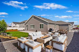 Virtually Staged - Rear view of property featuring an outdoor living space with a fire pit, a patio, and a lawn