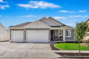 View of front facade featuring a garage and a front yard