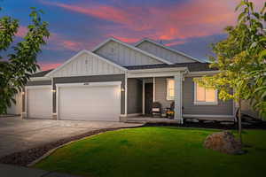 View of front facade featuring a lawn and a garage