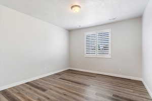 Primary BR:  Unfurnished room with hardwood / wood-style floors and a textured ceiling