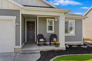 Property entrance with a garage and a porch