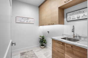 Laundry room featuring cabinets, hookup for a washing machine, and sink