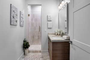 Bathroom featuring vanity and a shower with door