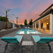 Pool at dusk featuring a patio