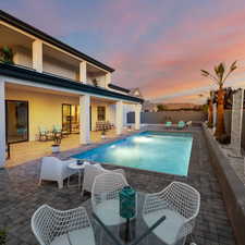 Pool at dusk featuring a patio area