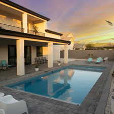 Pool at dusk featuring a patio area