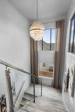 Stairs featuring hardwood / wood-style floors and an inviting chandelier