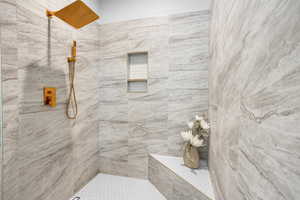 Bathroom featuring tile patterned flooring and tiled shower