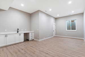 Laundry room with sink and light hardwood / wood-style flooring