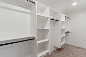 Walk in closet with light carpet