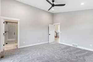 Spare room with a towering ceiling, ceiling fan, and light colored carpet