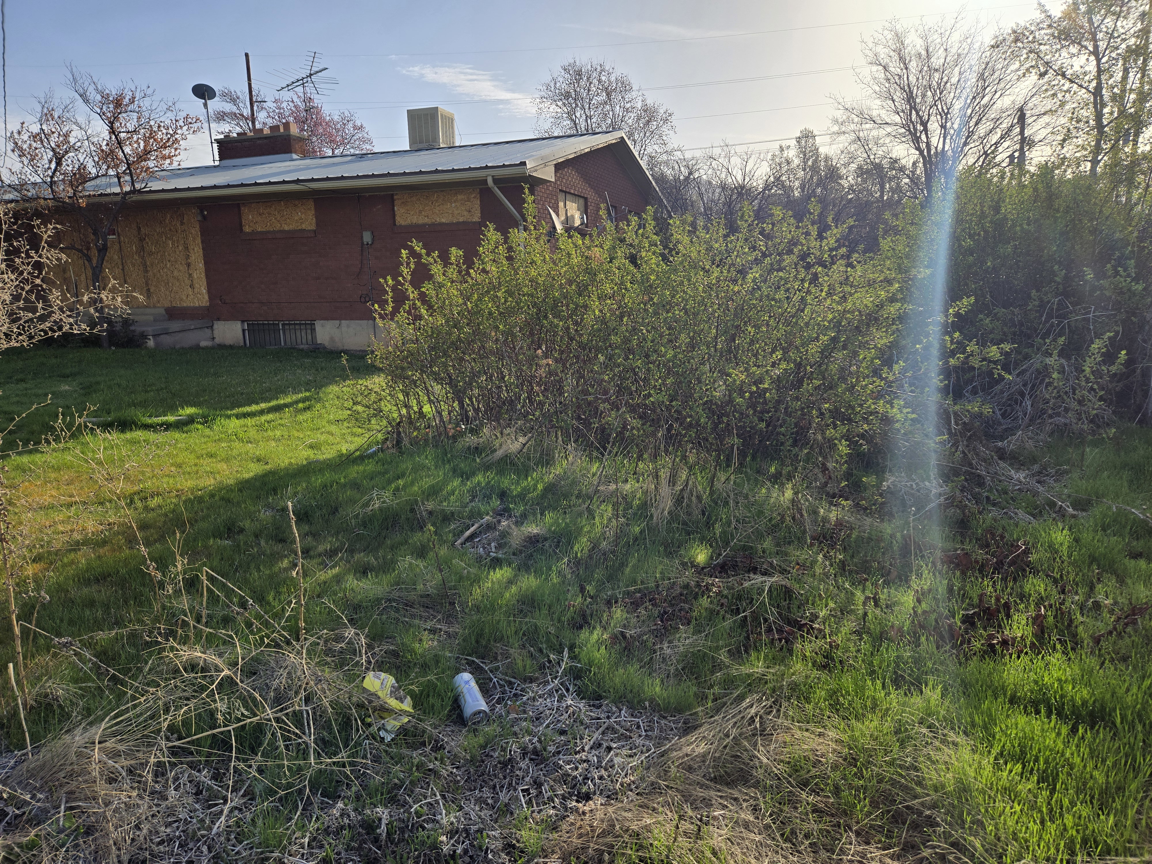 View of home's exterior with a yard, cooling unit, metal roof, and a chimney