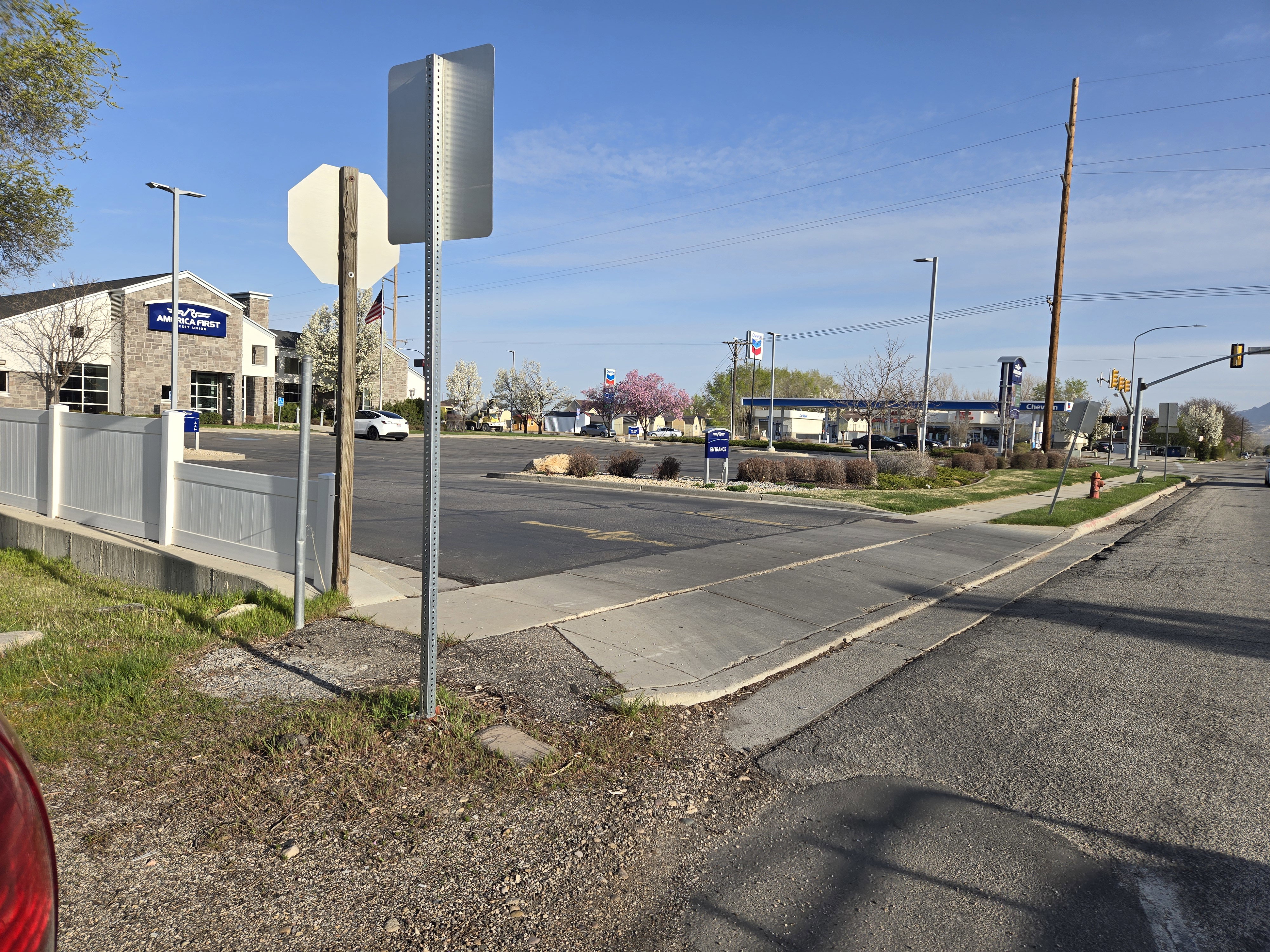 View of road with traffic lights, sidewalks, curbs, and traffic signs