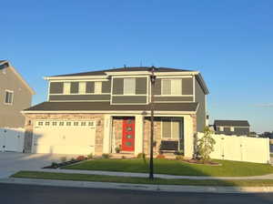 View of front facade with a garage and a front lawn