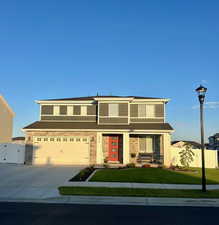 View of front facade featuring a garage and a front yard