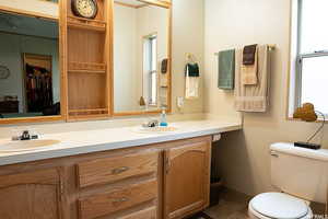 Bathroom featuring dual vanity, tile patterned flooring, and toilet