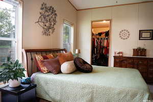 Bedroom with crown molding, a closet, and a spacious closet