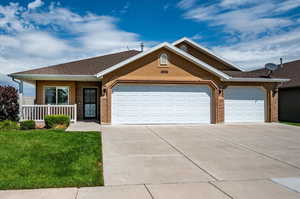 View of front facade with 3 car garage, patio, and  front corner yard